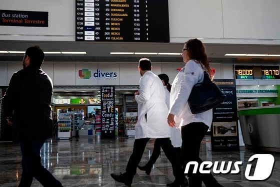 22일 (현지시간) 멕시코 검역 당국자들이 신종 코로나바이러스인 우한 폐렴의 방역 조치를 취하기 위해 티후아나 공항으로 들어서고 있다. © AFP=뉴스1