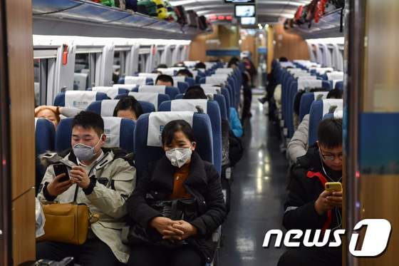 23일(현지시간) 중국 상하이에서 우한으로 향하는 열차에 춘제 귀성객들이 마스크를 쓴 채 탑승해 있다. © AFP=뉴스1