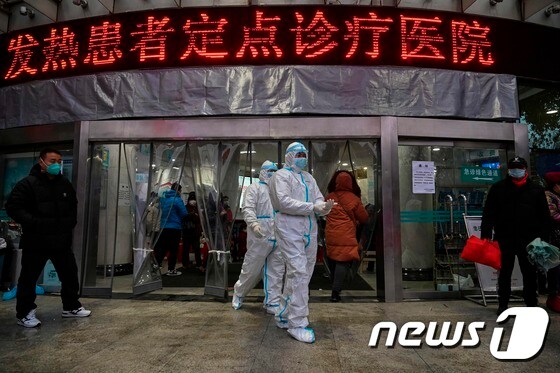 25일 중국 우한의 적십자병원에서 방호복과 마스크를 입은 의료진이 이동하고 있다. © AFP=뉴스1