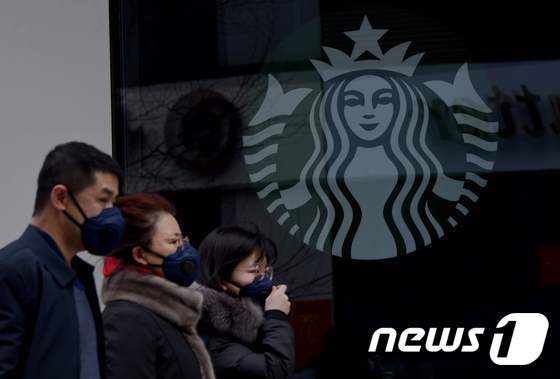 29일 중국 스타벅스 매장 앞에서 마스크를 하고 있는 시민들. © AFP=뉴스1