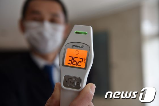 체온을 측정하는 호텔 직원. © AFP=뉴스1