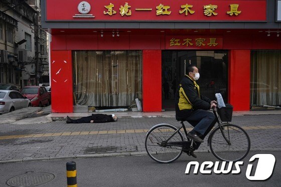 자전거를 탄 행인이 시신을 지나치고 있다.  © AFP=뉴스1