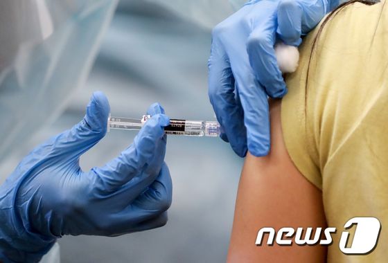지난 14일(현지시간) 미국 캘리포니아주 레이크우드의 무료 진료소에서 한 여성이 독감 백신을 맞고 있다. © AFP=뉴스1
