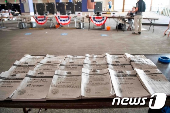  27일(현지시간) 미국 캘리포니아 베벌리힐스에 있는 한 투표소 책상에 여러 언어로된 투표 안내 팜플랫이 놓여 있다. 왼쪽 하단 두번째에 한글로 된 것도 보인다. © AFP=뉴스1