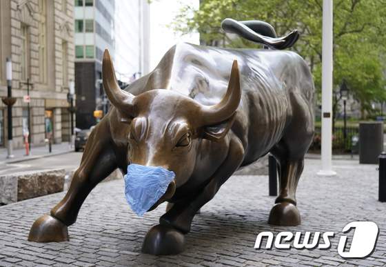 미국 뉴욕의 금융가 월스트리트를 상징하는 황소상에 마스크가 씌어져 있는 모습. © AFP=뉴스1