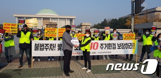 16일 서울 여의도 국회의사당 앞에서 수원 권선구 체육시설 반대 집회를 열고, 김진표 국회의원 측에 '반대 서명서'를 전달하고 있는 수원아이파크시티 입주민들. © 뉴스1
