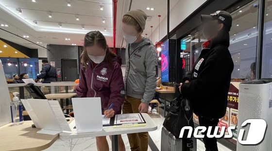 18일 오후 서울 용산구의 한 쇼핑몰 내 패스트푸드점에 시민들이 출입자 수기명부를 작성하고 있다. 2020.11.18/뉴스1 © News1 김진환 기자