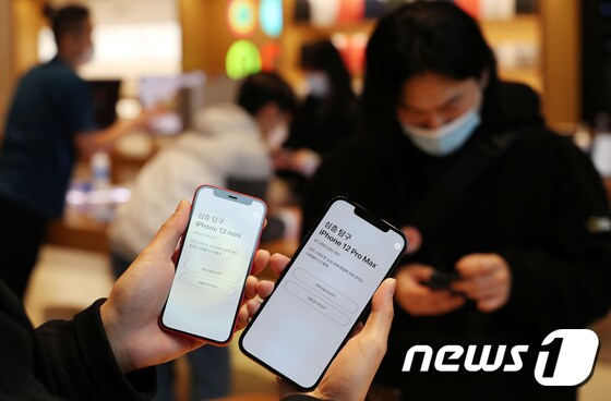 애플의 아이폰12 프로맥스와 아이폰12 미니가 공식 출시한 20일 오전 서울 강남구 가로수길 애플스토어에서 한 고객이 아이폰12 프로맥스와 미니를 비교하고 있다. 2020.11.20/뉴스1 © News1 박지혜 기자