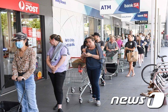 호주 사우스오스트레일리아주 주민들이 봉쇄조치 발표에 식료품을 사기 위해 슈퍼마켓 앞에 길게 줄을 서 있다. © AFP=뉴스1