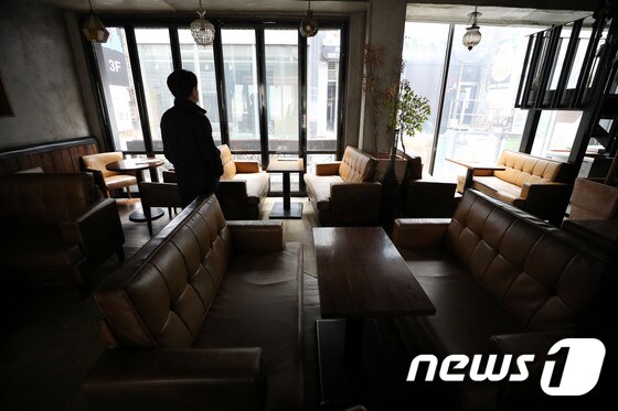 수도권 지역의 사회적 거리두기가 2단계로 격상된 24일 장사를 접은 서울 중구의 한 카페에서 주인이 창밖을 바라보고 있다. 2020.11.24/뉴스1 © News1 이광호 기자