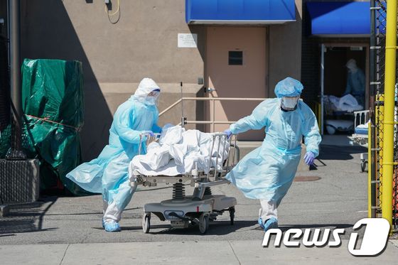 지난 4월 뉴욕 브루클린의 위코프 병원에서 의료진이 시신을 옮기고 있다. © AFP=뉴스1