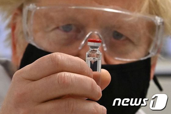 코로나19 백신을 들여다보고 있는 보리스 존슨 영국 총리. © AFP=뉴스1