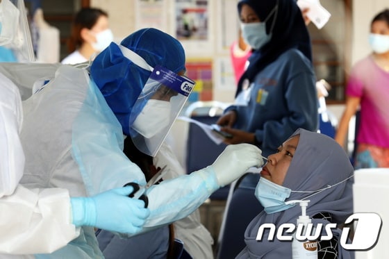 말레이시아 의료진이 코로나19 검사를 하고 있다. © 로이터=뉴스1
