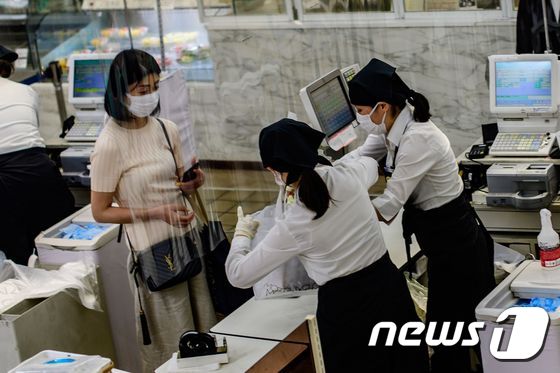 일본의 한 대형마트에서 계산원들이 투명 가림막을 앞에 두고 일하고 있다. © AFP=뉴스1