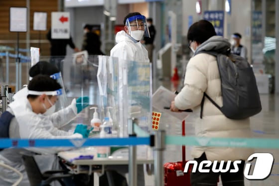 지난해 12월30일 오후 인천국제공항 입국장에서 해외발 입국자들이 방역 당국의 안내를 받고 있다. © News1  