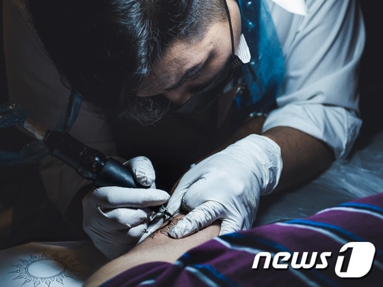 타투이스트 이유철씨가 고객의 몸에 문신을 새겨 넣고 있다. (노마드 스튜디오 제공)© 뉴스1