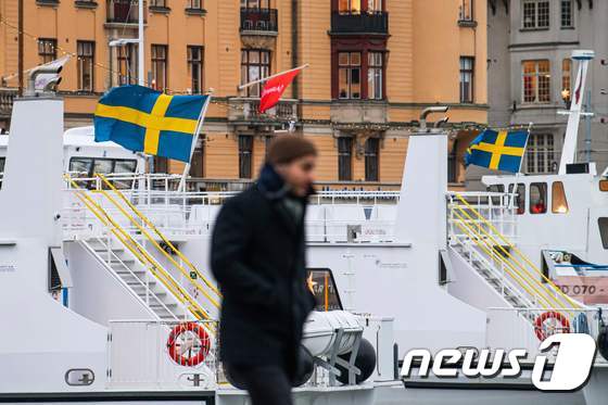 3일 스웨덴 스톡홀름의 통근용 페리. 그 앞에선 마스크를 쓰지 않은 행인이 걷고 있다. © AFP=뉴스1