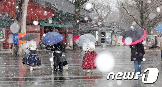 눈이 내린 16일 전북 전주시 한옥마을 찾은 관광객들이 우산을 쓰고 눈 내리는 거리를 걷고 있다. <br />2020.2.16/뉴스1 © News1 유경석 기자