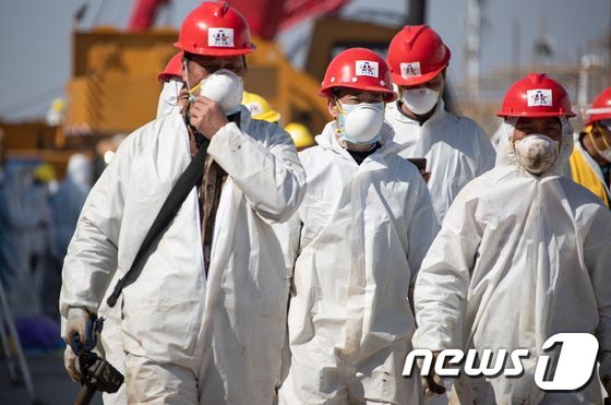 18일 (현지시간) 코로나19 발원지인 후베이성 우한에서 응급 병원인 레이선산병원의 건설 근로자들이 마스크를 쓰고 현장으로 가고 있다. © AFP=뉴스1 © News1 우동명 기자