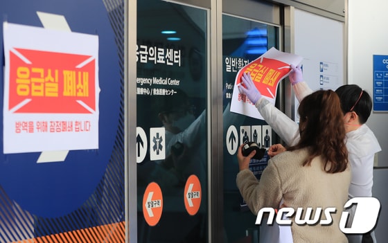 19일 오전 서울 성동구 한양대병원에서 해외여행력이 없는 신종 코로나바이러스 감염증(코로나19) 확진환자가 발생하면서 병원 관계자들이 응급실 폐쇄 안내문을 붙이고 있다. 병원측은 
