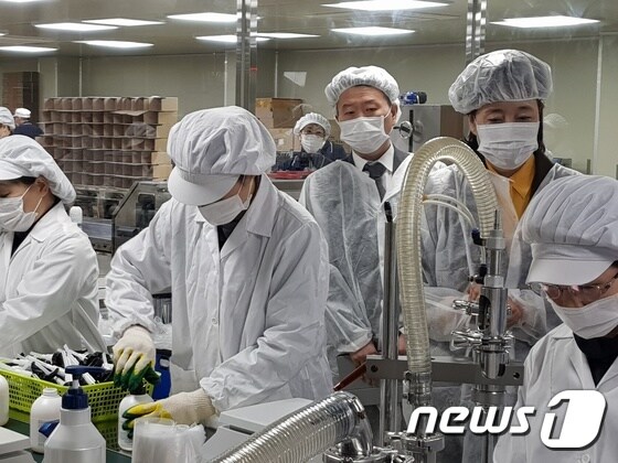 박영선 장관(뒷줄 오른쪽)이 우신화장품 공장에서 손소독제가 생산되는 모습을 점검하고 있다. © News1 조현기 기자
