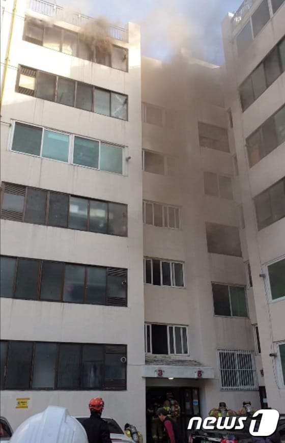 22일 오후 4시8분쯤 부산 수영구 남천동의 한 6층짜리 아파트  6층에서 불이 나 소방대원들이 화재 진화 작업을 벌이고 있다.(부산소방재난본부 제공)© 뉴스1