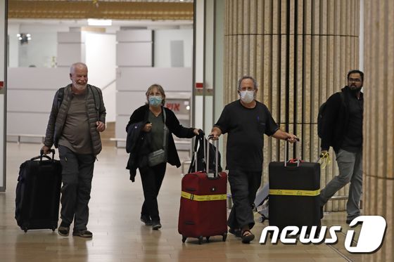 22일 이스라엘 벤구리온 국제공항에서 마스크를 쓴 여행객들이 이동하고 있다. © AFP=뉴스1