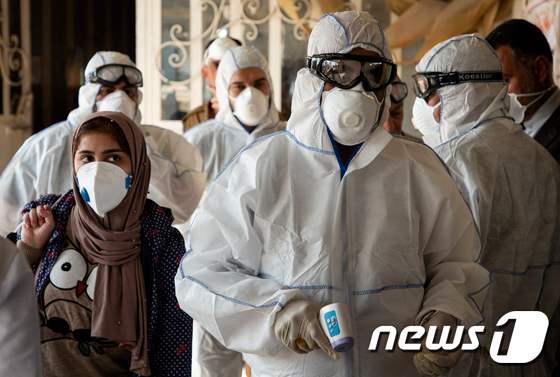 이라크 의료진이 이란에서 입국한 여행객들을 대상으로 체온 검사를 실시하고 있다. © AFP=뉴스1