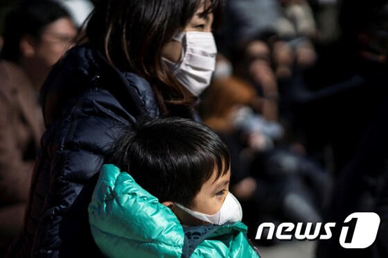 23일 일본 도쿄 우에노 공원에 나온 한 여성과 어린이가 마스크를 착용하고 있다. © 로이터=뉴스1