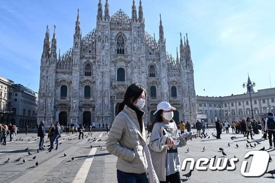 이탈리아 밀라노에서 두 명의 여성이 마스크를 쓴 채 두오모 앞을 걷고 있다. © AFP=뉴스1