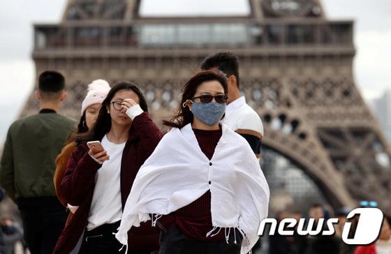 지난 1일(현지시간) 프랑스 파리 에펠탑 앞에서 한 여성이 중국발 신종 코로나바이러스 예방을 위해 마스크를 쓰고 있다. © 로이터=뉴스1 © News1 정윤미 기자