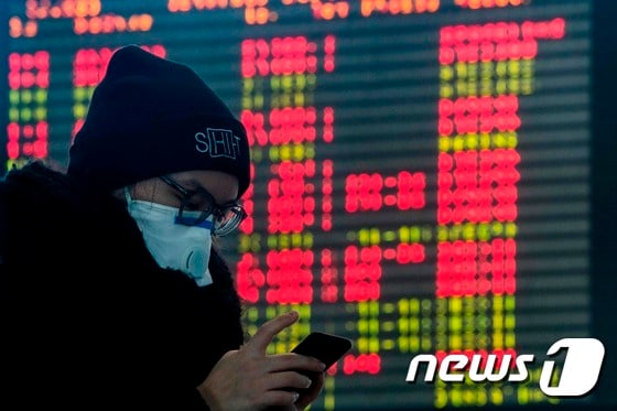 13일(현지시간) 체코 프라하에 있는 국제공항 출국장에서 마스크를 쓴 여행객이 휴대폰을 들여다보고 있다. © AFP=뉴스1