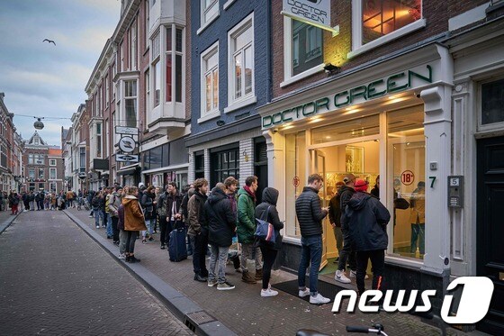네덜란드 헤이그의 한 카페 앞에 사람들이 줄을 길게 서 있다. 네덜란드 정부는 신종 코로나바이러스 감염증(코로나19) 확산을 막기 위해 모든 술집과 식당 등의 영업을 16일부터 3주 간 중단토록 했다. © AFP=뉴스1