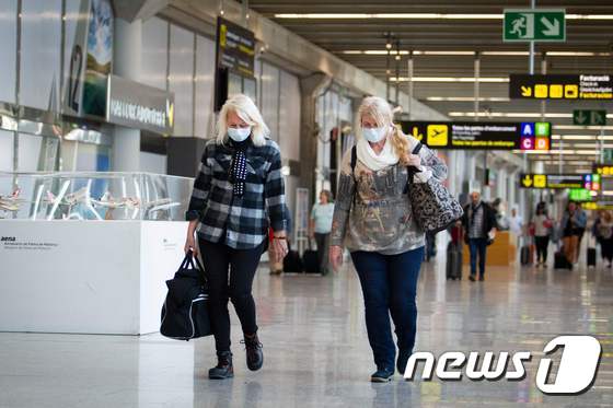 스페인 팔마데마요르카 소재 한 공항에서 두 여행객이 마스크를 쓰고 다니고 있다. © AFP=뉴스1