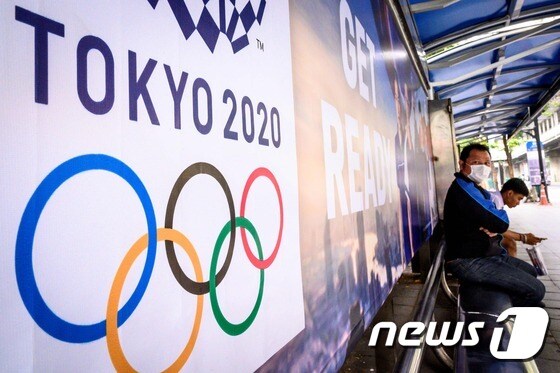 국제올림픽위원회(IOC)가 신종 코로나바이러스 감염증(코로나19) 확산에 도쿄 올림픽 출전을 위한 권투 종목의 유럽 지역 예선전을 중단한다고 발표했다. IOC는 16일(현지시간) 성명을 내고 지난 14일 영국 런던에서 시작해 24일까지 진행될 예정이었던 유럽 예선전을 이날 저녁 경기를 끝으로 더는 진행하지 않는다고 밝혔다. 사진은 코로나19 확산 우려 속에 마스크를 쓴 한 남성이 16일(현지시간) 방콕의 도쿄 2020 올림픽 광고 앞 버스 정류장에 앉아 있다. © AFP=뉴스1 © News1 이동원 기자