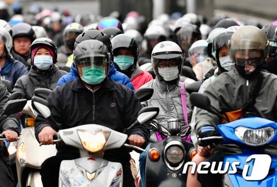 18일(현지시간) 대만 타이베이에서 코로나19 감염을 막기위해 마스크를 쓴 시민들이 오토바이를 타고 출근을 하고 있다. © AFP=뉴스1 © News1 우동명 기자