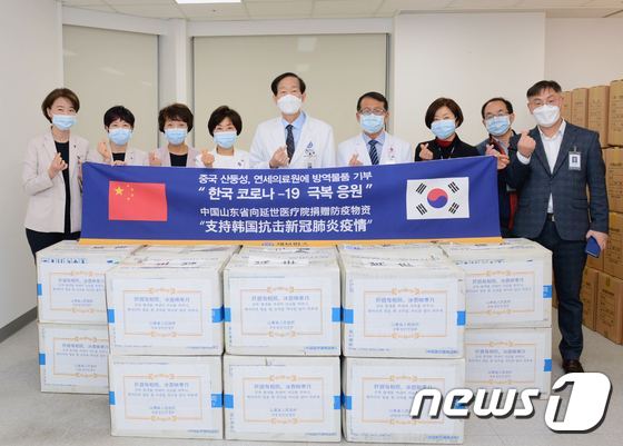 중국 산둥성 정부가 기부한 마스크 5만장에 대한 감사를 표시하고 있는 윤도흠 (사진 왼쪽에서 다섯번째) 연세의료원장과 직원들.© 뉴스1