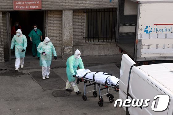 스페인 마드리드의 그레고리오 마라논 병원에서 의료진들이 숨진 코로나19 환자를 이송하고 있다. © AFP=뉴스1 © News1 우동명 기자