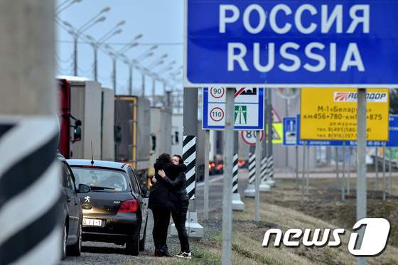 러시아와 벨라루스 국경 폐쇄를 하루 앞둔 29일(현지시간) 한 가족이 국경 인근에서 작별 인사를 하고 있다.  © AFP=뉴스1