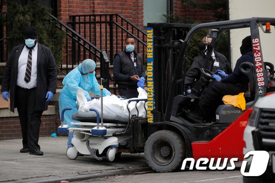 미국 뉴욕의 브루클린 병원 앞에서 지난달 30일(현지시간) 코로나19 사망자 시신이 지게차로 옮겨지고 있다. © 로이터=뉴스1