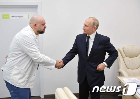지난 24일 블라디미르 푸틴 러시아 대통령이 신종 코로나바이러스 감염증(코로나19) 확진 판정을 받은 의사 데니스 프로첸코와 악수를 나누고 있다. © AFP=뉴스1