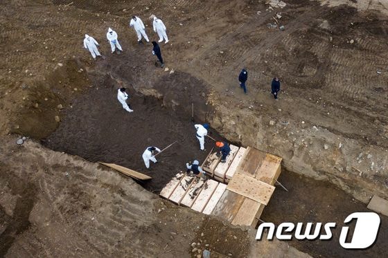 9일 (현지시간) 뉴욕의 하트 아일랜드에서 방호복을 입은 인부들이 코로나19 사망자의 관을 매장하고 있다. © 로이터=뉴스1 © News1 우동명 기자