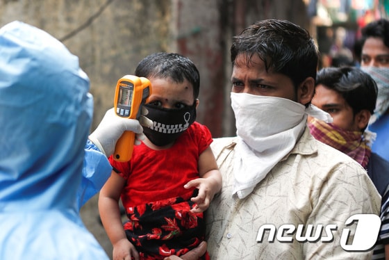 11일(현지시간) 인도 뭄바이에 있는 아시아 최대 빈민가 다라비에서 의료진들이 주민들의 체온을 검사를 하고 있다. © 로이터=뉴스1