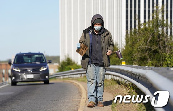 3일 미국 버지니아주 폴스처치의 한 도로에서 한 실업자 남성이 마스크와 장갑을 착용한 채 걷고 있다. © 로이터=뉴스1