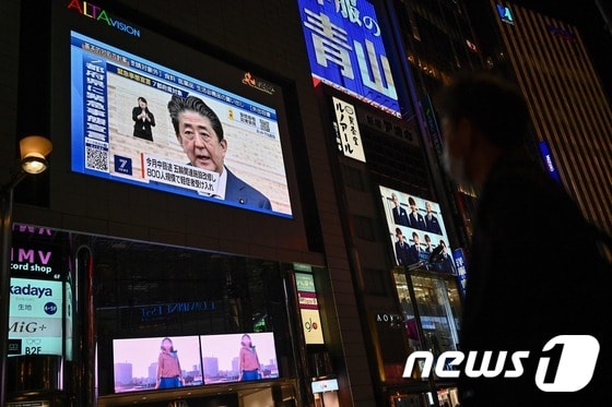 7일 아베 총리의 기자회견 장면이 도쿄 신주쿠거리의 대형 스크린에 나오고 있다. © AFP=뉴스1