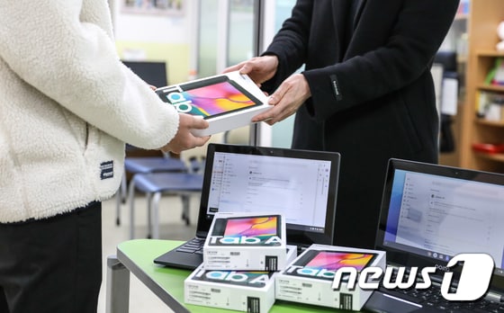'온라인 개학'을 하루 앞둔 8일 서울의 한 중학교에서 학생이 태블릿PC를 지급받고 있다. 2020.4.8/뉴스1 © News1 박종홍 기자