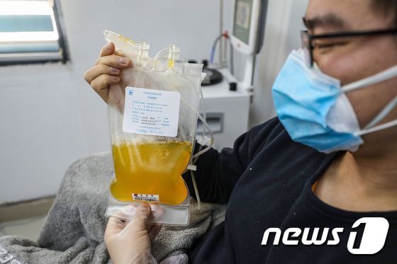 중국에서 신종 코로나바이러스 감염증(코로나19) 환자를 대상으로 회복기 혈장을 투여하는 '혈장치료'를 시행한 결과 환자들의 상태가 개선됐다는 연구결과가 공개됐다. 사진은 중국에서 코로나19에서 완치된 환자가 혈장을 뽑은 후 들고있는 모습 © AFP=뉴스1