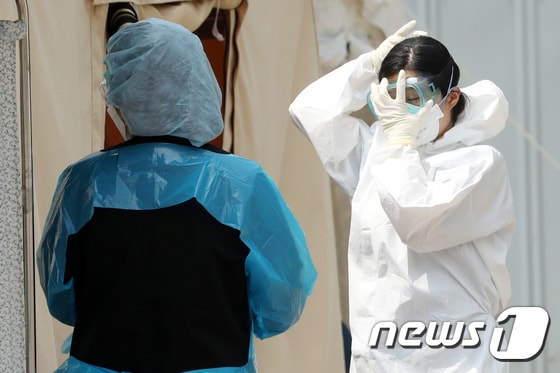 지난 12일 오후 서울 중랑구 서울의료원에서 한 의료진이 고글을 고쳐쓰고 있다. 2020.5.12/뉴스1 © News1 이동해 기자