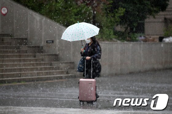 18일 오후 서울 용산구 서울역 인근에서 한 시민이 우산을 쓰고 발걸음을 옮기고 있다. 2020.5.18/뉴스1 © News1 이승배 기자