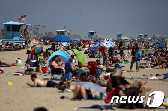 24일(현지시간) 미국 캘리포니아주 헌팅턴 해변에 인파가 몰려들어 일광욕을 즐기고 있다. © 로이터=뉴스1
